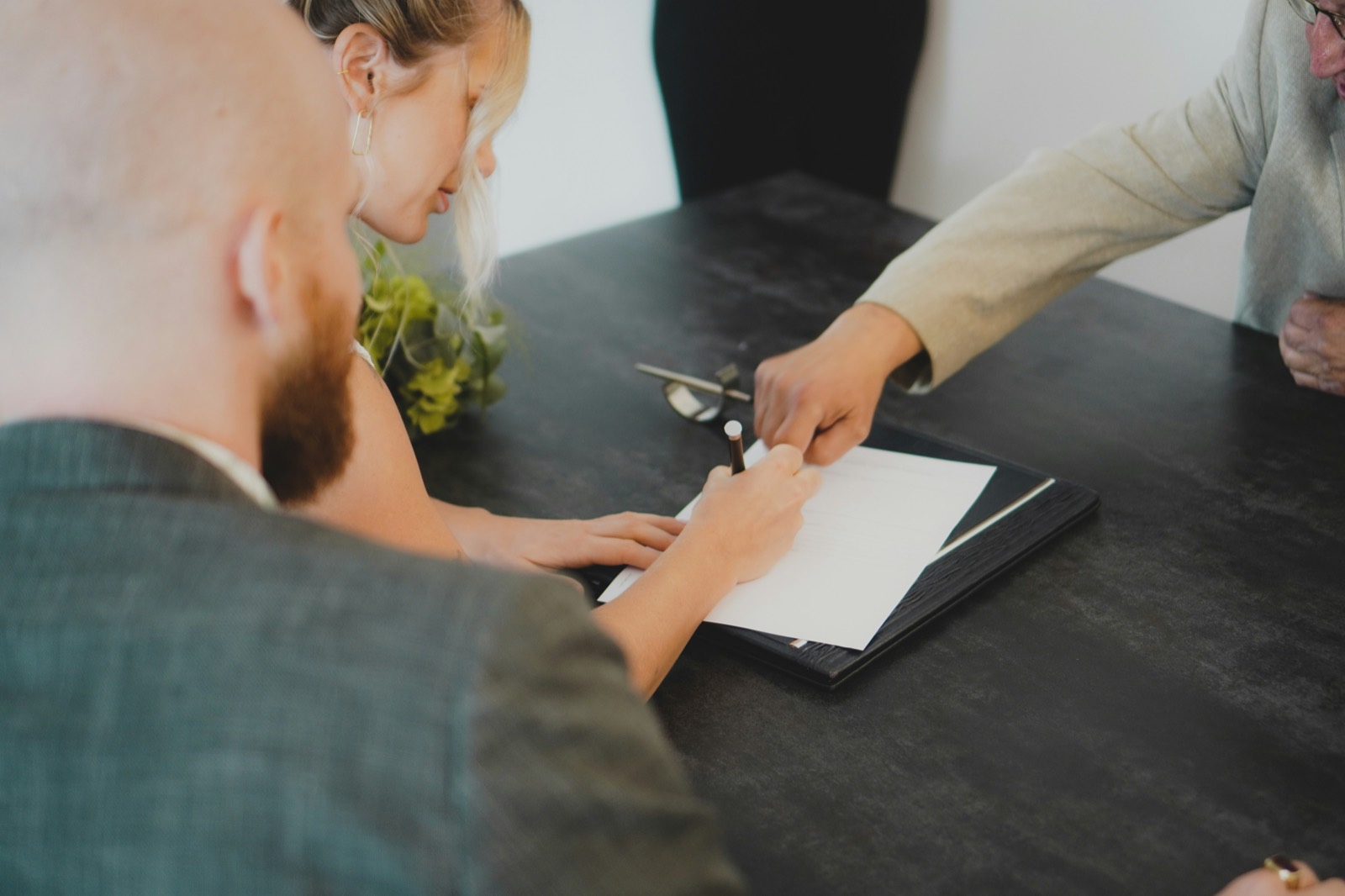 An insurance agent reviewing paperwork with clients at an agency desk