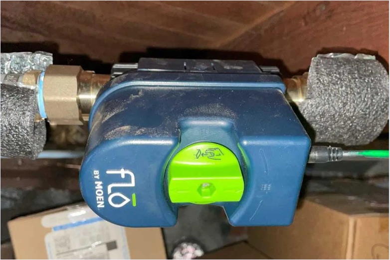 Close view of a Moen Flo smart water shutoff installed on a water line